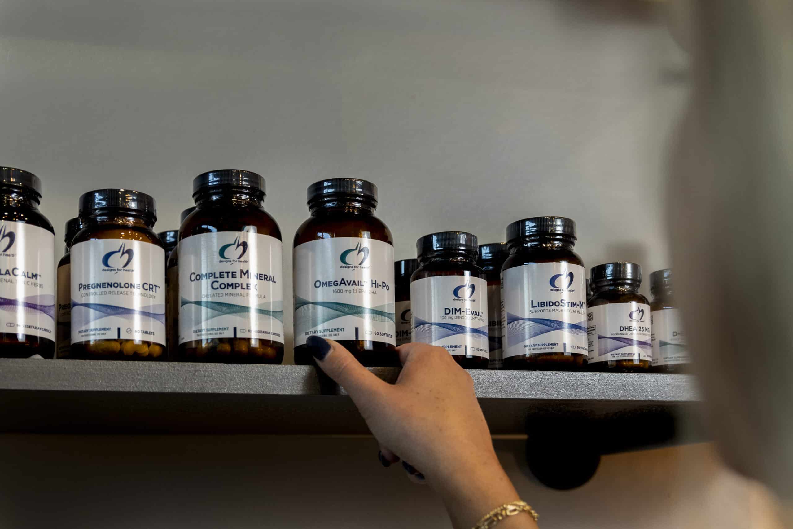 Bottles of Designs for Health supplements arranged on a clean surface, showcasing professional packaging and health-focused labels.